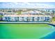 An aerial exterior showcases condos with balconies facing tranquil turquoise waters, perfect for waterfront living at 7420 Bay Island S Dr # 281, South Pasadena, FL 33707