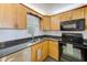 Updated kitchen featuring black appliances and light oak wood cabinets at 7420 Bay Island S Dr # 281, South Pasadena, FL 33707