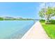 Waterfront walkway with grass, greenery, and nearby condo building, providing a pleasant walk at 7420 Bay Island S Dr # 281, South Pasadena, FL 33707
