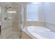 This bathroom showcases a separate shower and tub under a window with custom tile at 7570 Tamarind Ave, Tampa, FL 33625