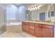 Bright bathroom featuring a soaking tub, separate shower, and double vanity with granite countertops at 7570 Tamarind Ave, Tampa, FL 33625