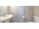 Clean half bathroom with a pedestal sink and a white toilet at 7570 Tamarind Ave, Tampa, FL 33625