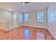 Bright living room with hardwood floors, two windows and neutral wall paint at 7570 Tamarind Ave, Tampa, FL 33625