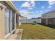 Spacious backyard featuring green grass, a privacy fence, and sliding glass doors at 8133 Canterbury Lake Blvd, Tampa, FL 33619