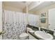 Bathroom featuring a toilet, sink, shower with floral shower curtain and a decorative mirror at 8133 Canterbury Lake Blvd, Tampa, FL 33619