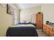 This bedroom has a bed with a blue comforter, wooden furniture, and wood floors at 8133 Canterbury Lake Blvd, Tampa, FL 33619