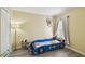 Bedroom with car-shaped bed, plush toys, and a window with blinds and curtains for soft light at 8133 Canterbury Lake Blvd, Tampa, FL 33619