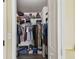 Walk-in closet with shelves and hanging racks filled with a variety of clothing and accessories at 8133 Canterbury Lake Blvd, Tampa, FL 33619