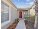 Home's front door is red and accentuated with surrounding landscaping. A gray wall is visible at 8133 Canterbury Lake Blvd, Tampa, FL 33619