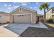 Charming single Gathering home with a two car garage, gray siding, and palm tree in the front yard at 8133 Canterbury Lake Blvd, Tampa, FL 33619