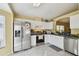 Galley kitchen features white cabinets, stainless steel appliances, gray countertops and light yellow walls at 8133 Canterbury Lake Blvd, Tampa, FL 33619