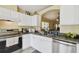 Cozy kitchen featuring white cabinets, stainless steel appliances and an archway through to another room at 8133 Canterbury Lake Blvd, Tampa, FL 33619