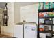 Functional laundry area with a modern washer and dryer, plus storage shelving at 8133 Canterbury Lake Blvd, Tampa, FL 33619