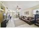 Open-concept living room featuring a brown leather sofa, a ceiling fan, and light yellow walls at 8133 Canterbury Lake Blvd, Tampa, FL 33619