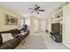 Light-filled living room featuring a brown leather sofa, a ceiling fan, and light yellow walls at 8133 Canterbury Lake Blvd, Tampa, FL 33619