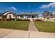 Attractive single-story home features a manicured lawn and charming front yard landscaping on a bright day at 921 57Th N Ave, St Petersburg, FL 33703