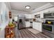 Bright kitchen with stainless steel appliances, white cabinets, and wood-look flooring at 921 57Th N Ave, St Petersburg, FL 33703