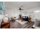 Cozy living room featuring painted brick walls, modern ceiling fan, and wood-look laminate flooring at 921 57Th N Ave, St Petersburg, FL 33703