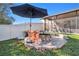 Backyard featuring an umbrella-covered patio set beside a brick fire pit, ideal for outdoor entertaining at 10108 Golden Wonder Ln, Riverview, FL 33578