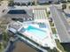Aerial view of the community pool, shuffleboard courts, clubhouse and surrounding landscaping at 10116 Tulip N St # 10116, Pinellas Park, FL 33782