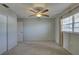 Bedroom with beige carpet, closet, window with blinds and curtains, and a ceiling fan at 10116 Tulip N St # 10116, Pinellas Park, FL 33782