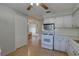 Charming kitchen with white cabinets, gas range, microwave and view of dining area at 10116 Tulip N St # 10116, Pinellas Park, FL 33782