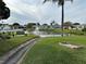 A tranquil community pond with a fountain, lush greenery and walkways along the perimeter at 10116 Tulip N St # 10116, Pinellas Park, FL 33782