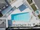 Aerial view of a community pool with lounge chairs, white fencing and a shuffleboard court at 10116 Tulip N St # 10116, Pinellas Park, FL 33782