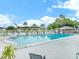 Beautiful community pool with lounge chairs, tables, and a surrounding green space at 10116 Tulip N St # 10116, Pinellas Park, FL 33782