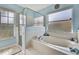 Bathroom featuring a soaking tub, glass-enclosed shower, and a window with natural light at 11381 Tuscanny Ave, Spring Hill, FL 34608