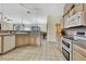 Well-lit kitchen with neutral cabinets and an open floor plan connecting to the living area at 11381 Tuscanny Ave, Spring Hill, FL 34608