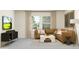 Inviting living room with a comfortable brown sectional sofa, modern tv, natural light, and a plush rug at 11542 E 71St Ter, Palmetto, FL 34221