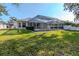Well-maintained backyard featuring a screened-in pool area and lush green lawn at 12545 Leatherleaf Dr, Tampa, FL 33626