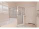 Bathroom featuring enclosed glass shower, a white soaking tub, and plantation shutters at 12545 Leatherleaf Dr, Tampa, FL 33626