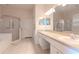 Bright bathroom with double sink vanity, walk-in shower, and tiled flooring at 12545 Leatherleaf Dr, Tampa, FL 33626