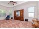 Bright bedroom with large windows, tray ceiling, and built in wooden storage at 12545 Leatherleaf Dr, Tampa, FL 33626