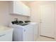 Convenient laundry room with modern washer and dryer, storage cabinets and a utility sink at 12545 Leatherleaf Dr, Tampa, FL 33626