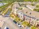 Aerial view of townhouses with brick accents, balconies, and tree-lined parking areas in a community at 12557 Bassbrook Ln, Tampa, FL 33626