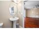 Clean half-bathroom featuring a pedestal sink, round mirror, and neutral walls at 12557 Bassbrook Ln, Tampa, FL 33626