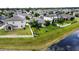 An aerial view of a neighborhood featuring well-maintained homes, lawns and a tranquil lake at 13359 Orca Sound Dr, Riverview, FL 33579