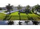 View of the manicured backyard featuring a well-kept lawn with mature trees and a serene pond at 13359 Orca Sound Dr, Riverview, FL 33579