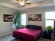 Bright bedroom with a ceiling fan, potted plants, and decorative wall art at 13359 Orca Sound Dr, Riverview, FL 33579