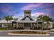 Community clubhouse exterior featuring classic design elements, metal roofing, and manicured landscaping at 13359 Orca Sound Dr, Riverview, FL 33579