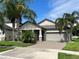 Charming single Gathering home featuring a two-car garage, complemented by tropical landscaping and a brick paved driveway at 13359 Orca Sound Dr, Riverview, FL 33579