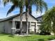 Charming home with stone pillar accents and a quaint sitting area, framed by lush landscaping and mature palm trees at 13359 Orca Sound Dr, Riverview, FL 33579