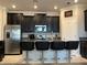 Stylish kitchen featuring dark cabinetry, a granite-topped island with seating, and stainless steel appliances at 13359 Orca Sound Dr, Riverview, FL 33579
