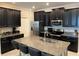 Modern kitchen with a granite-topped island with seating, stainless steel appliances, and sleek black cabinetry at 13359 Orca Sound Dr, Riverview, FL 33579