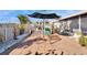 Back patio with pavers, an umbrella table, white stone, and a glimpse of a play set and a pool at 13507 Mango Bay Dr, Riverview, FL 33579