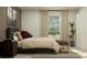 Inviting bedroom featuring a comfortable bed, bench, and a sunlit window at 15083 Zircon Red Dr, Wimauma, FL 33598