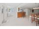 Bright open-concept living space with tiled floors, laundry, bar seating, and dining area at 16004 2Nd E St, Redington Beach, FL 33708
